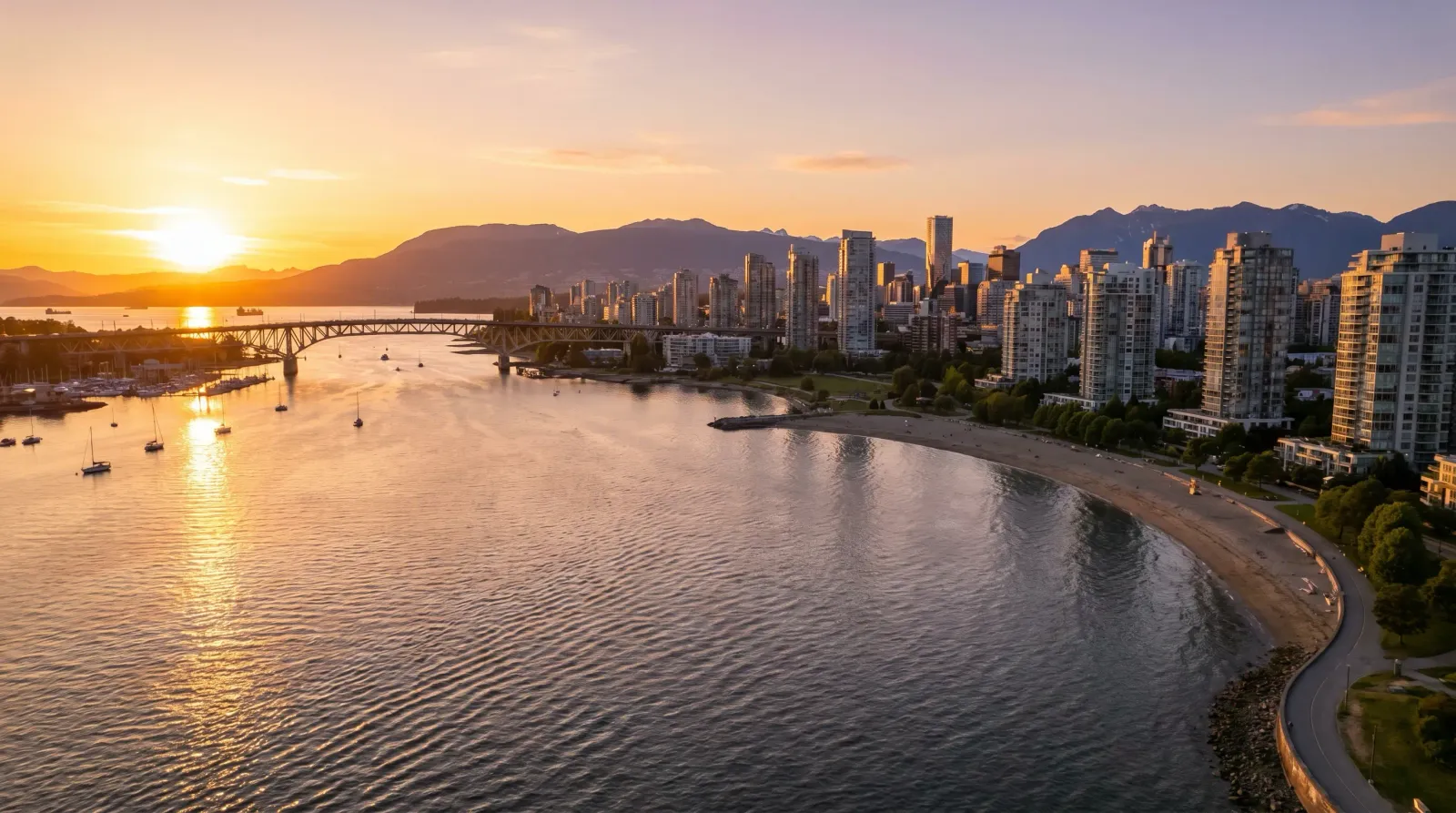 Vancouver English Bay coastline at sunset with downtown skyline, Burrard Bridge, and North Shore mountains in summer 2026